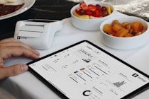 A person sitting at a table with a tablet