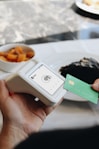 A person holding a credit card in front of a plate of food