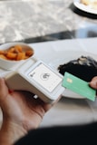 A person holding a credit card in front of a plate of food