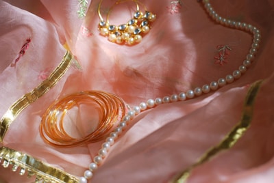 A close up of jewelry on a pink cloth