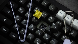A computer keyboard with a yellow flower on it