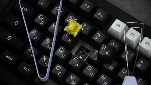 A computer keyboard with a yellow flower on it