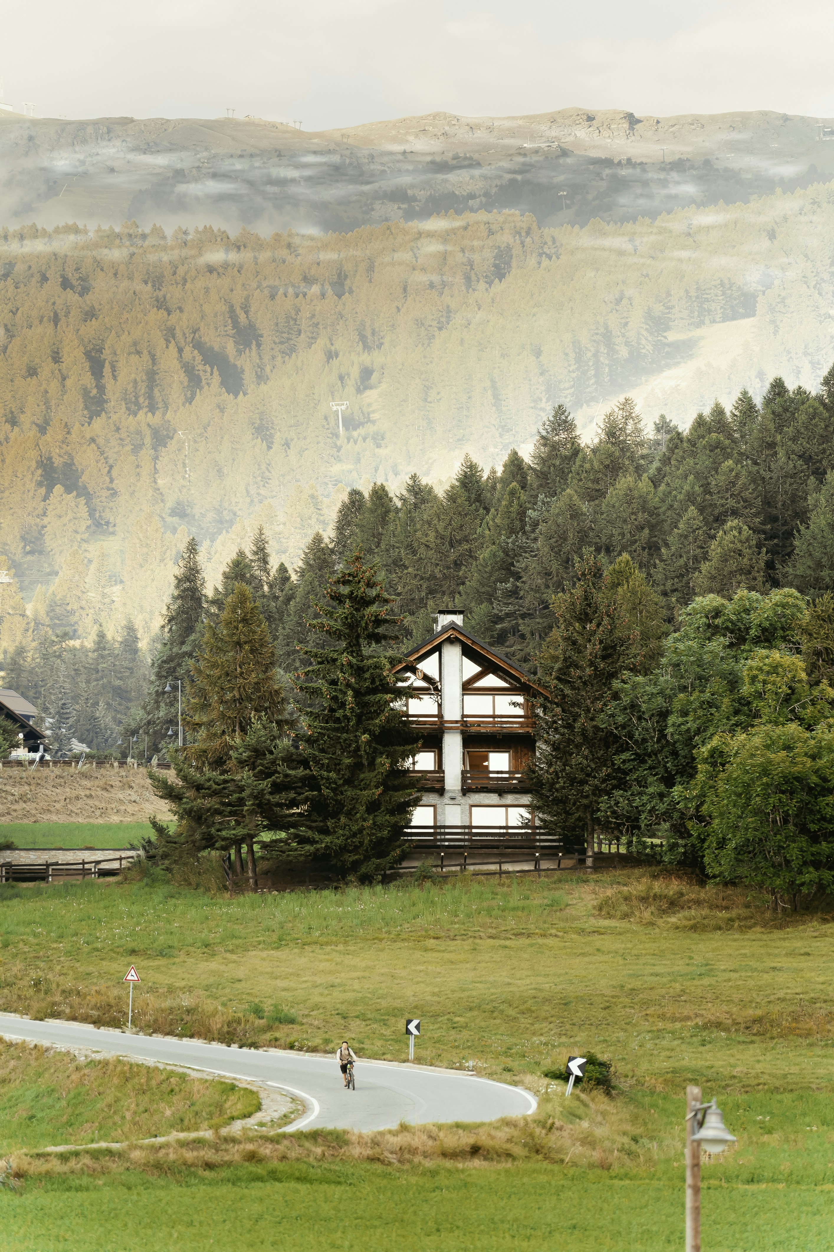 A house in the middle of a field with a mountain in the background