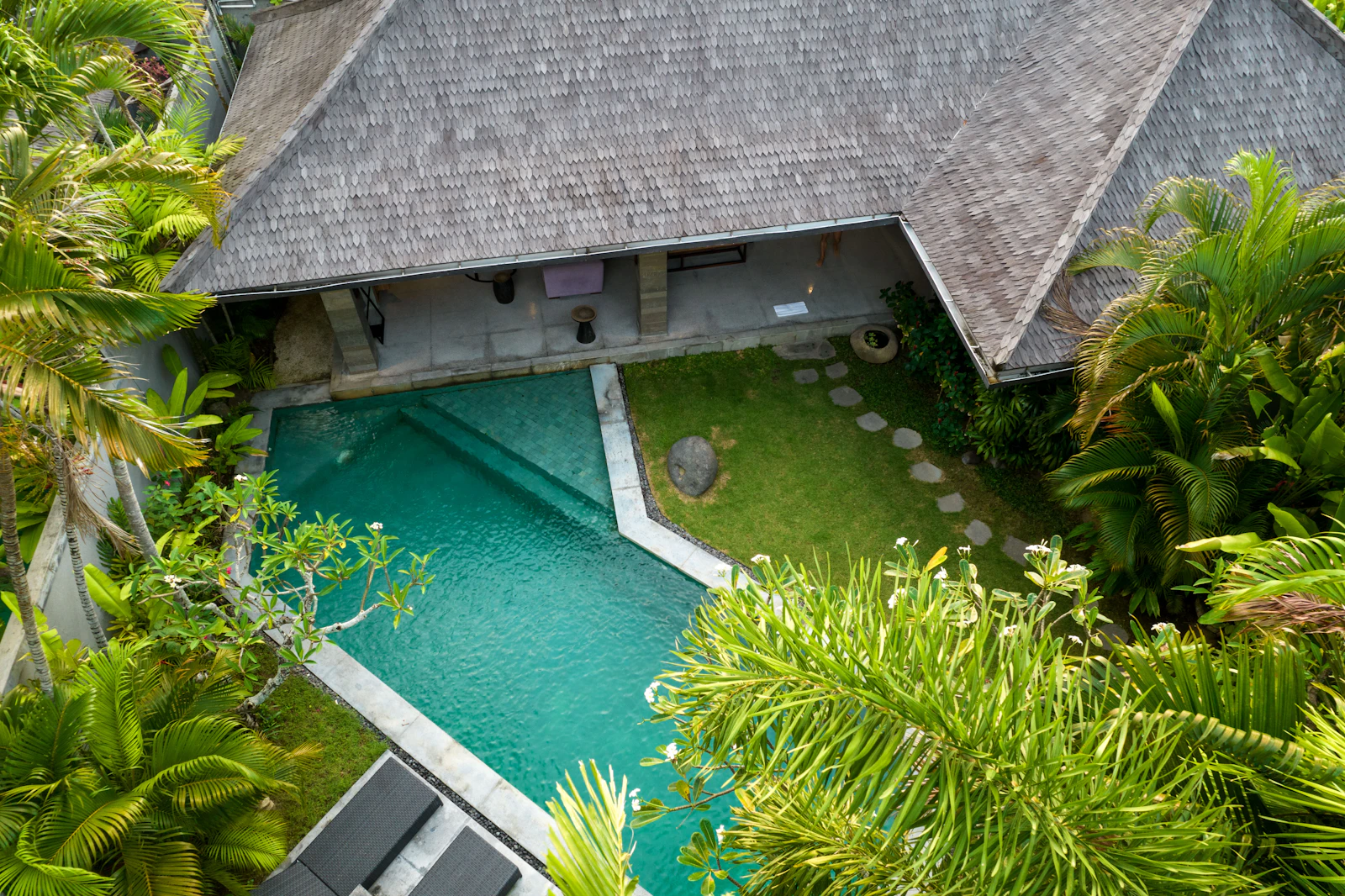 House among dense canopy seen from above