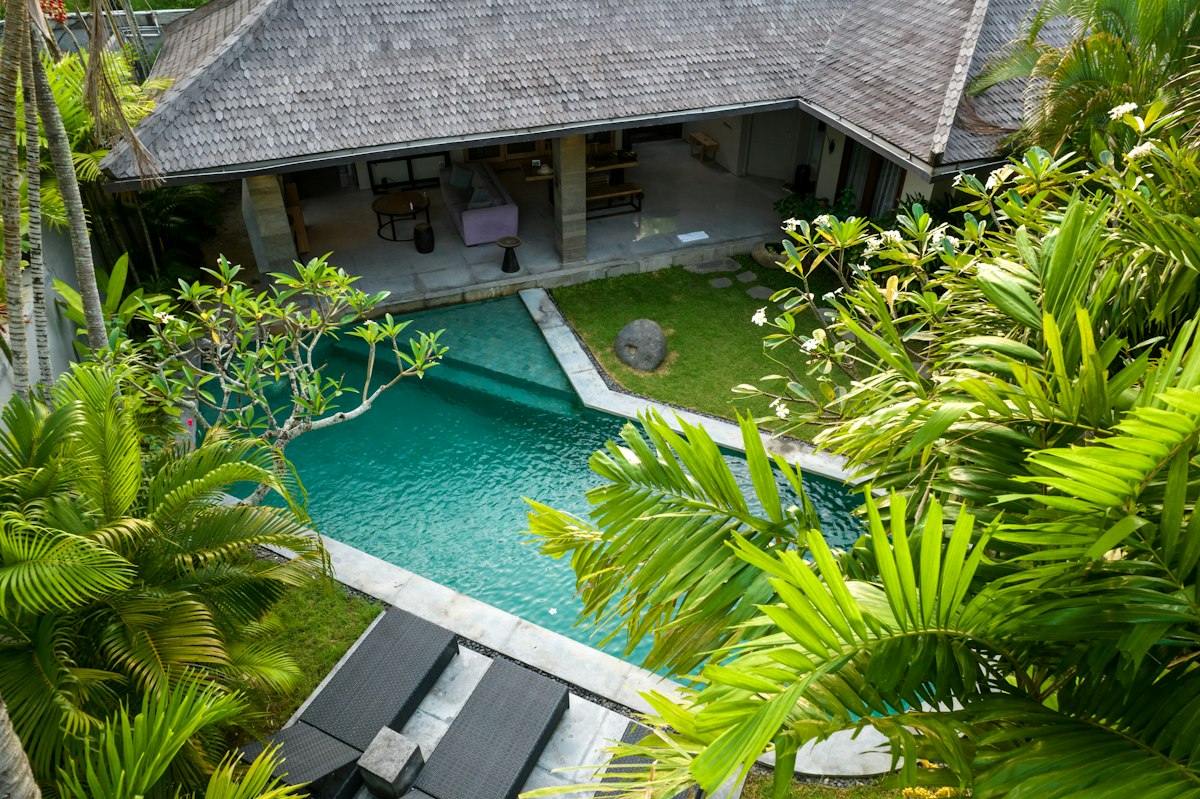 Aerial view of a private pool villa surrounded by palm trees in Bali