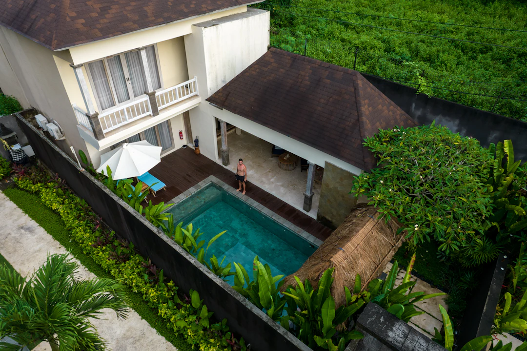 The villa and its pool seen from above, surrounded by gardens