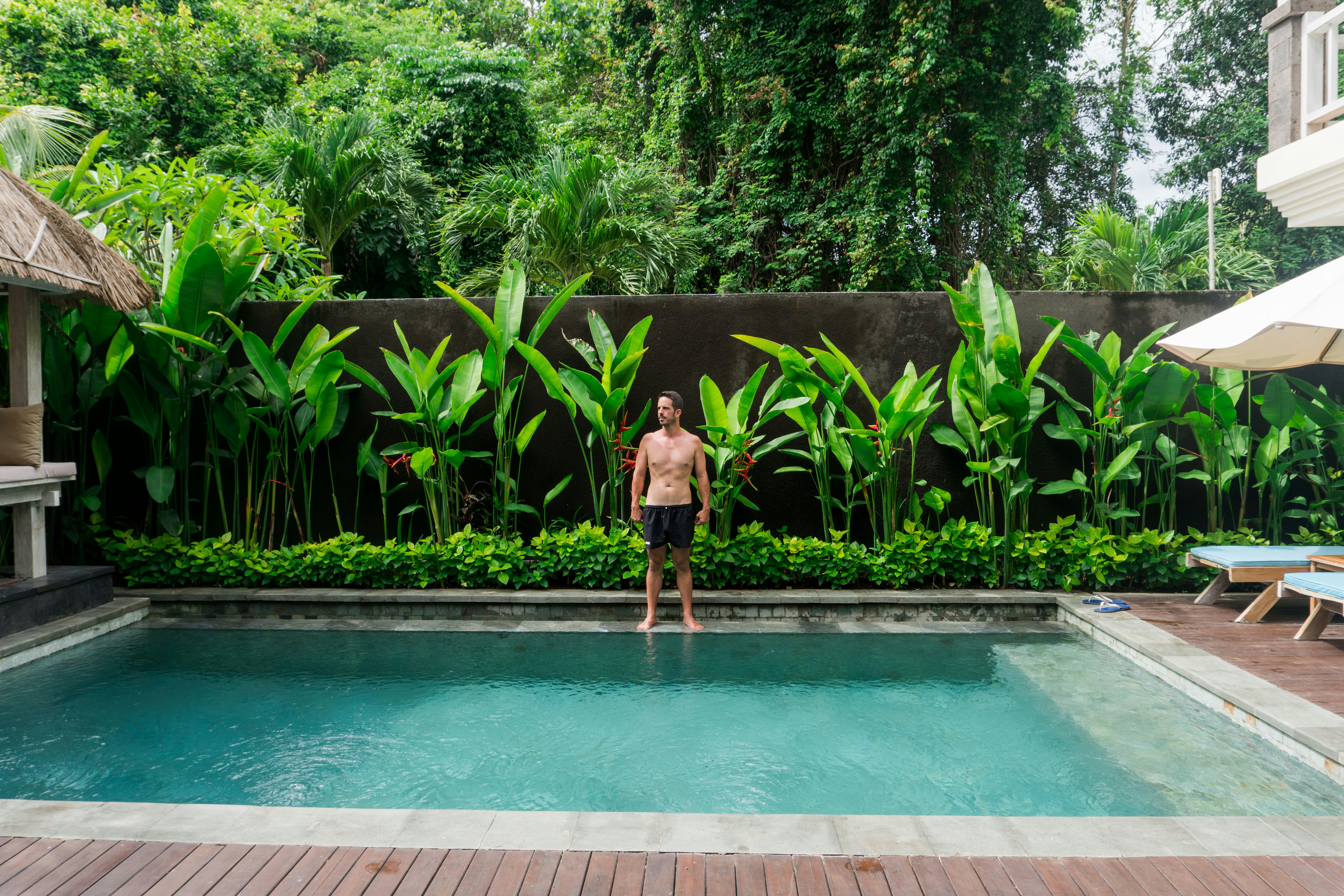 Man standing by luxury pool