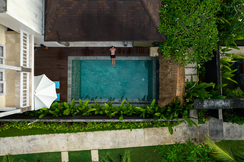 Tropical living villa exterior with aerial view of pool and greenery