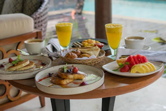 A wooden table topped with plates of food