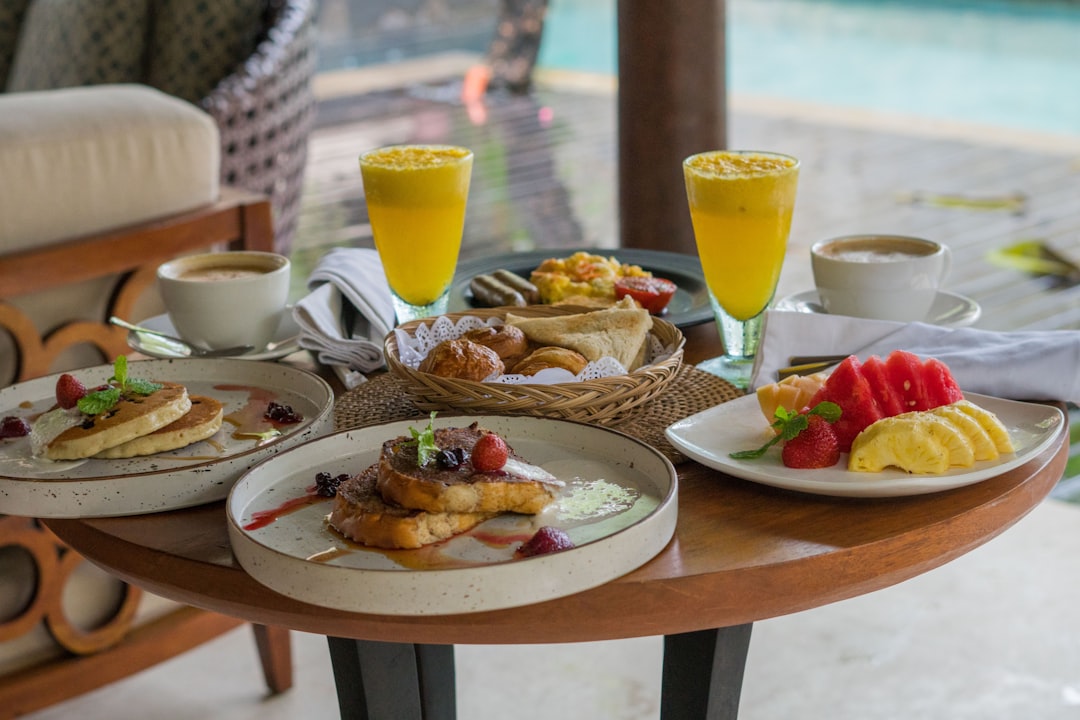 A wooden table topped with plates of food,