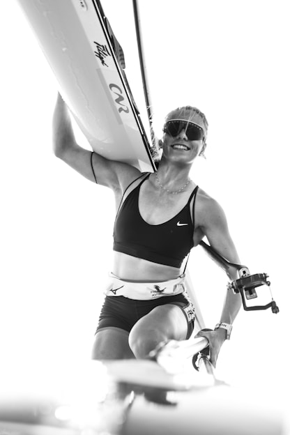 A woman holding a surfboard on top of a body of water