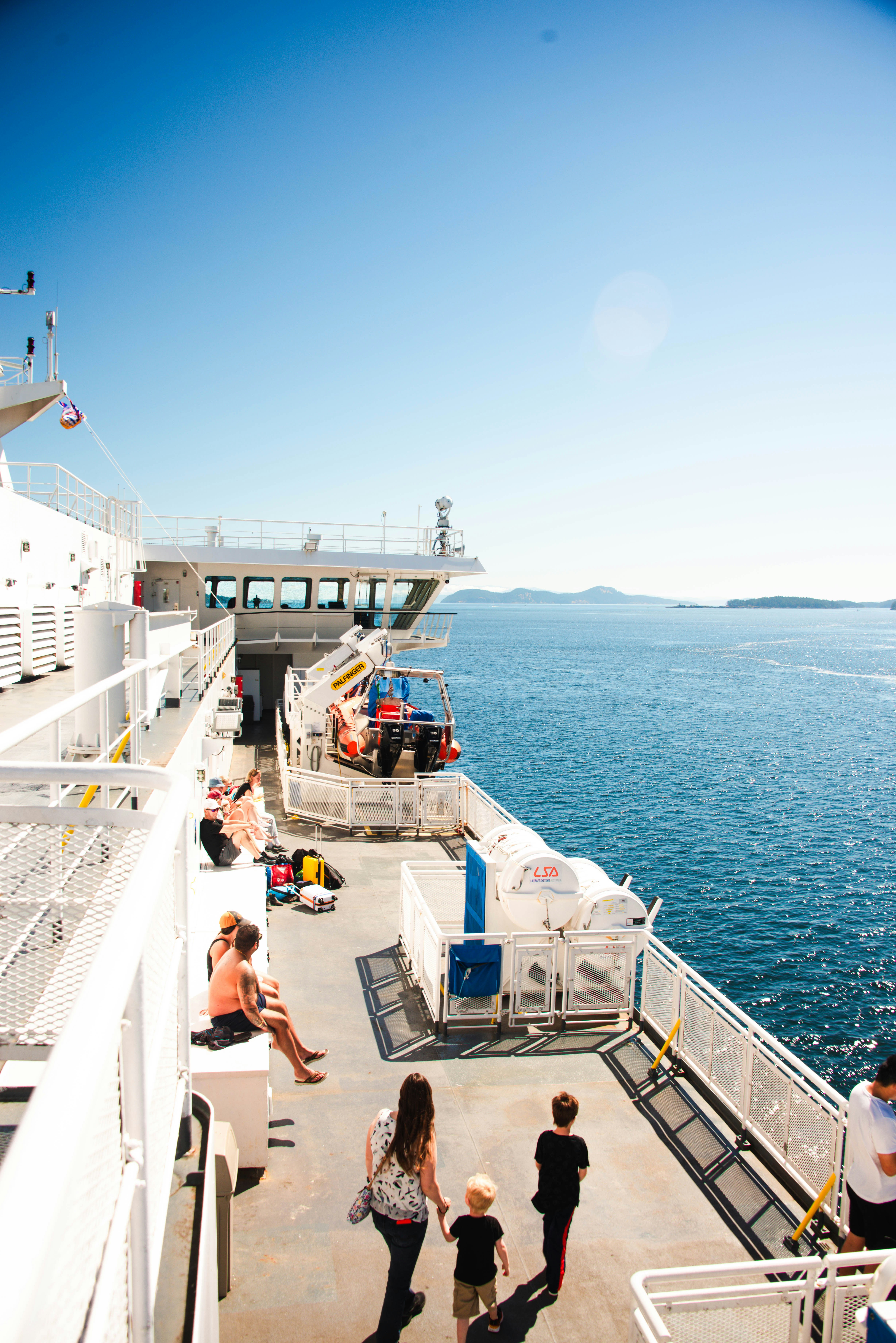 A group of people standing on the side of a boat