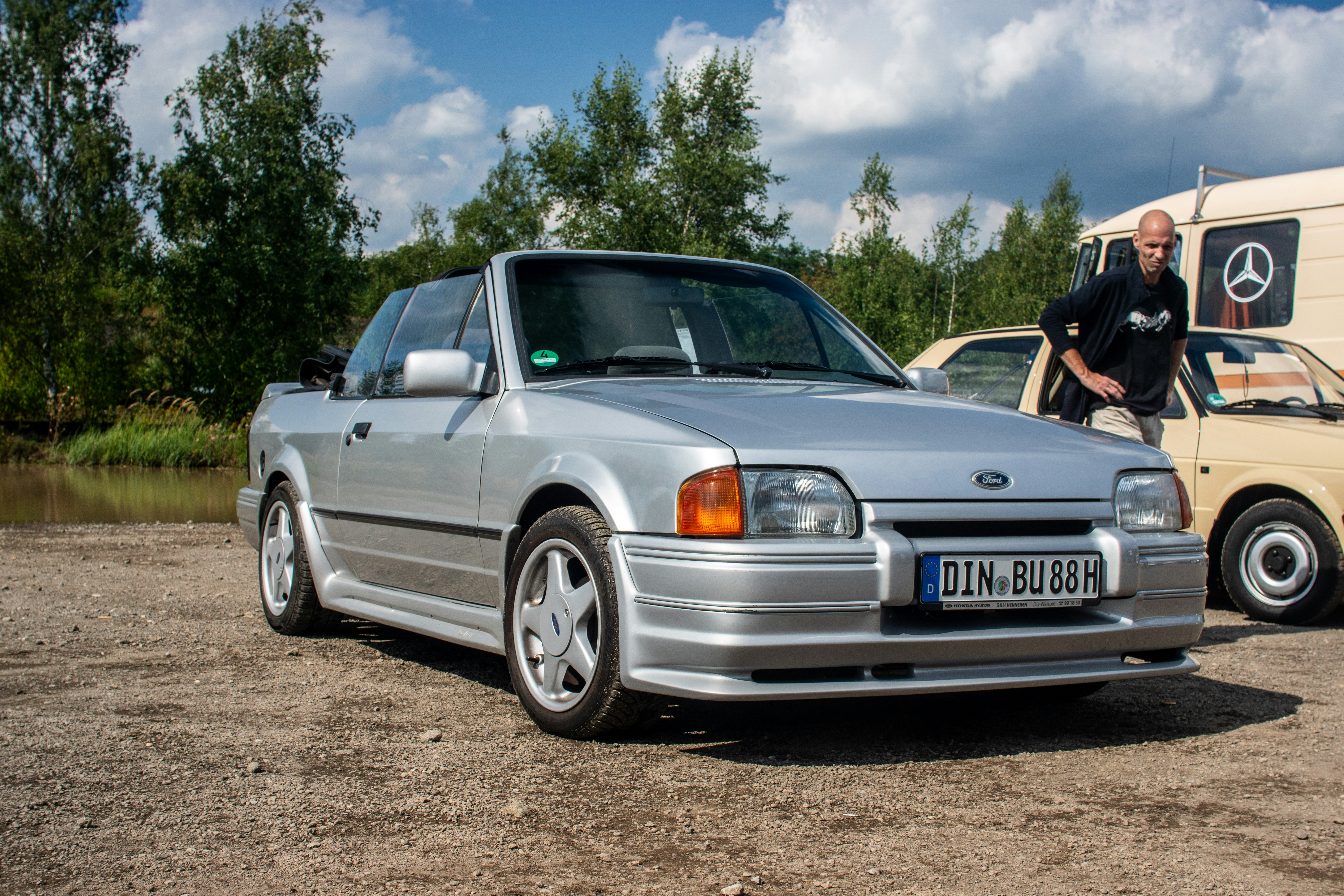 A silver car parked next to a white van
