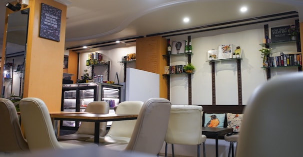 A room filled with lots of white chairs and tables