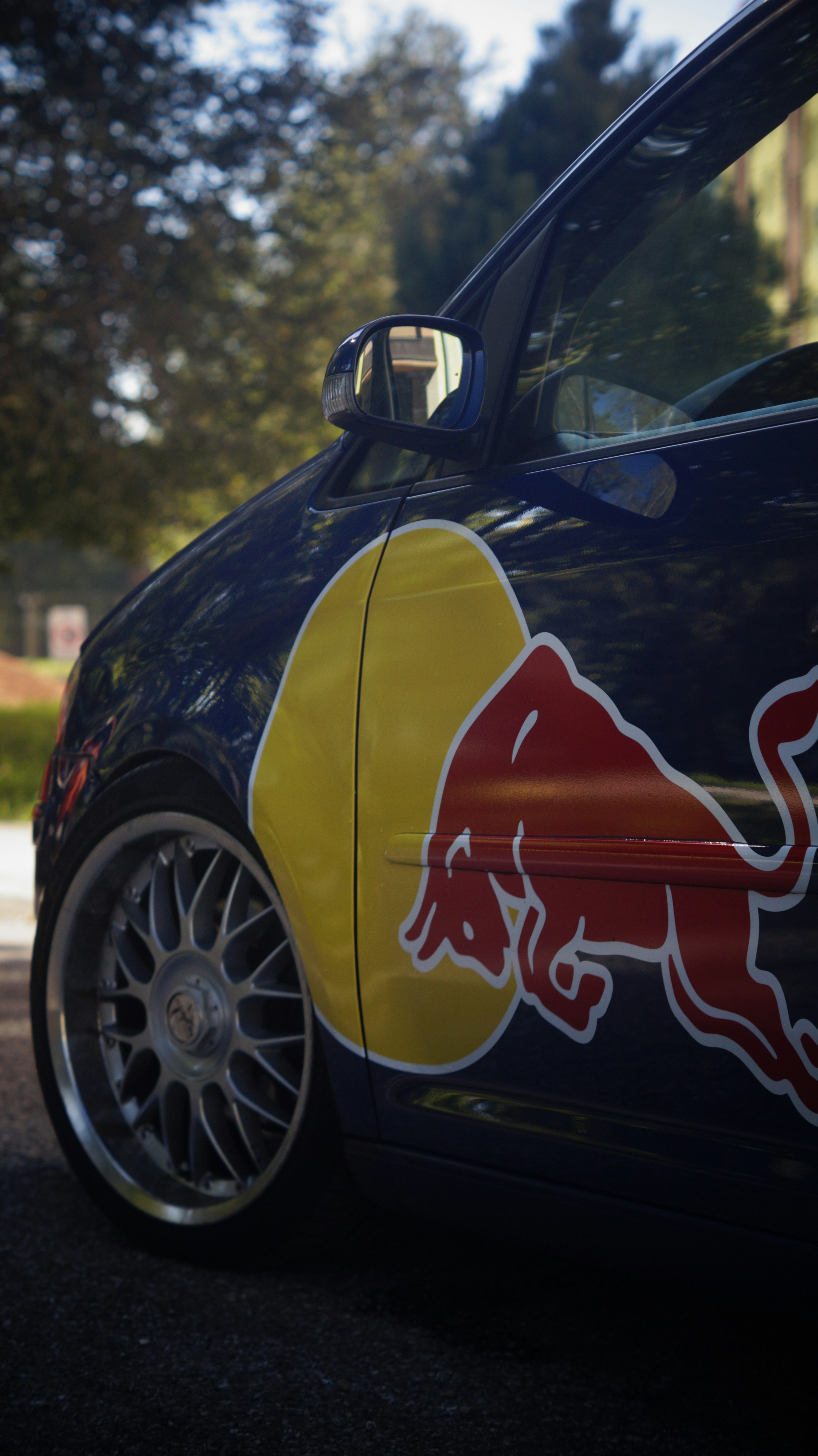 A close up of a car with a red bull painted on it