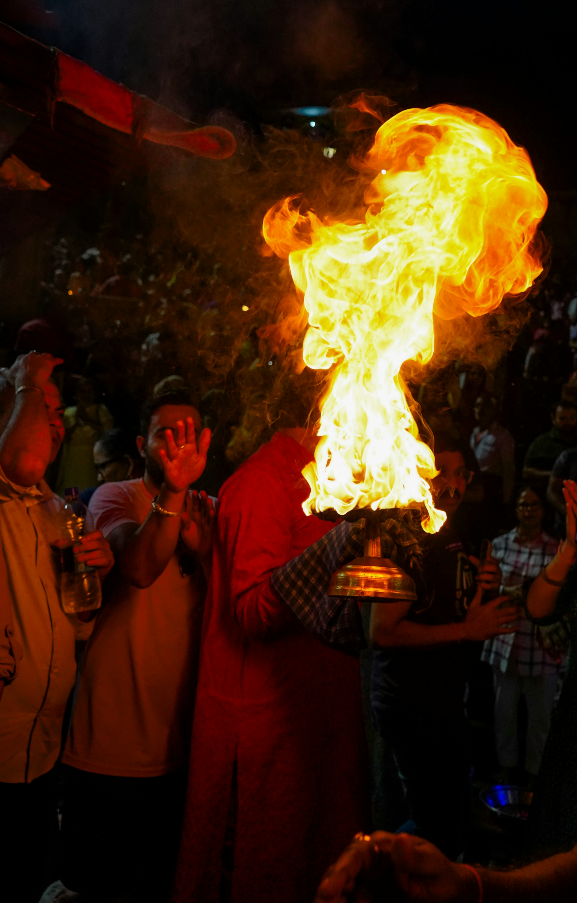A group of people standing around a fire pit