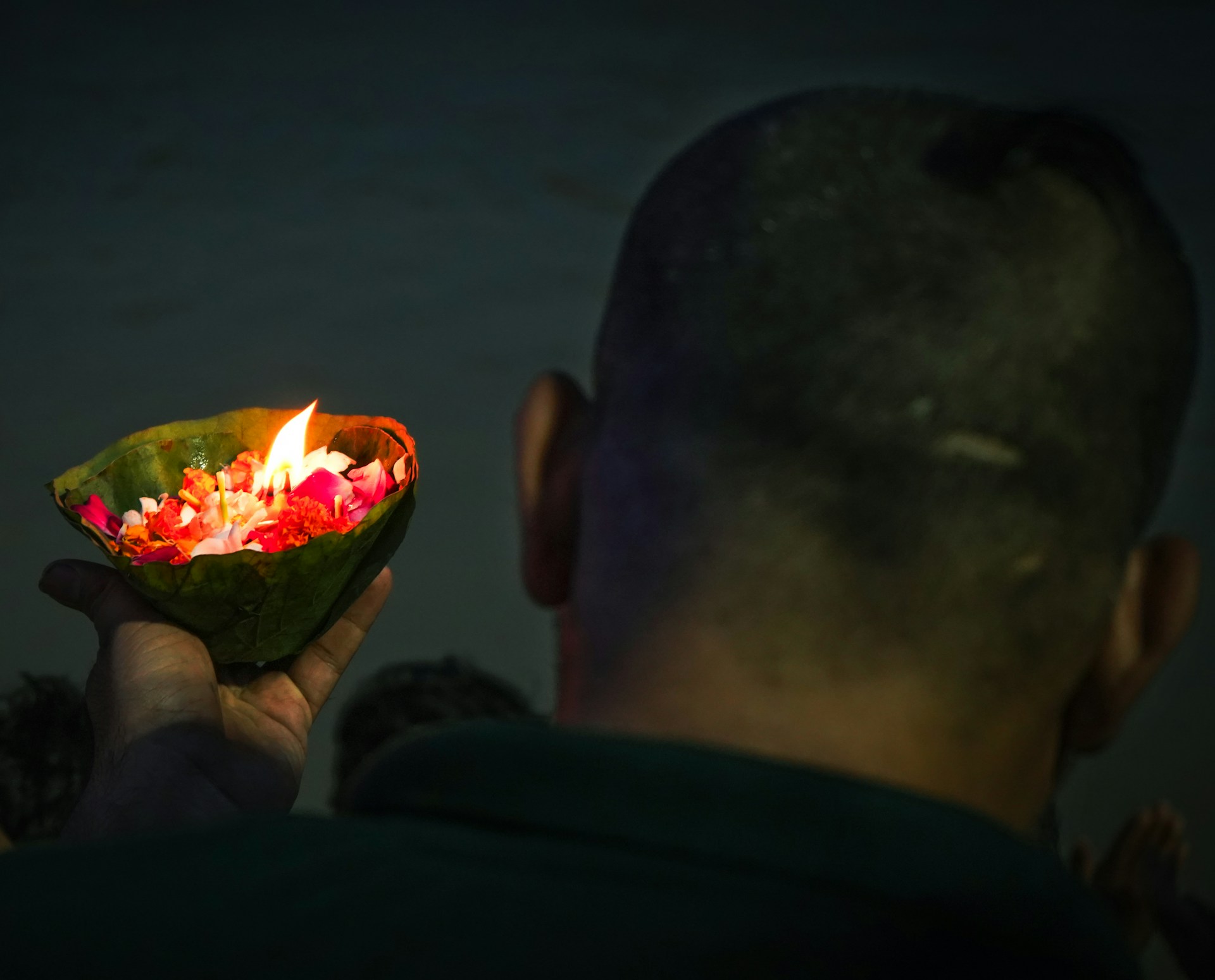 A man holding a lit candle in his hand