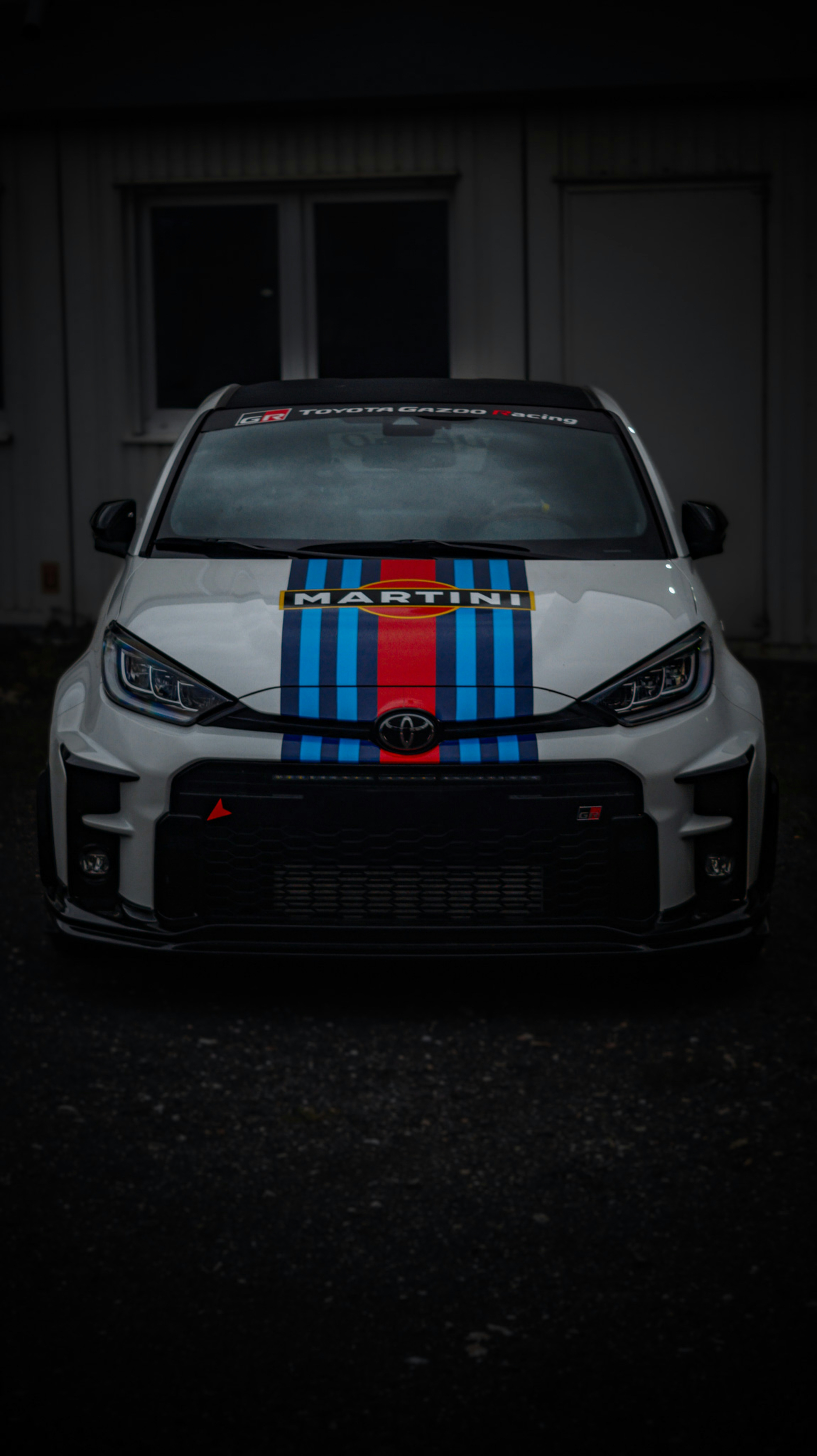 Mobil putih dengan garis merah dan biru di atasnya