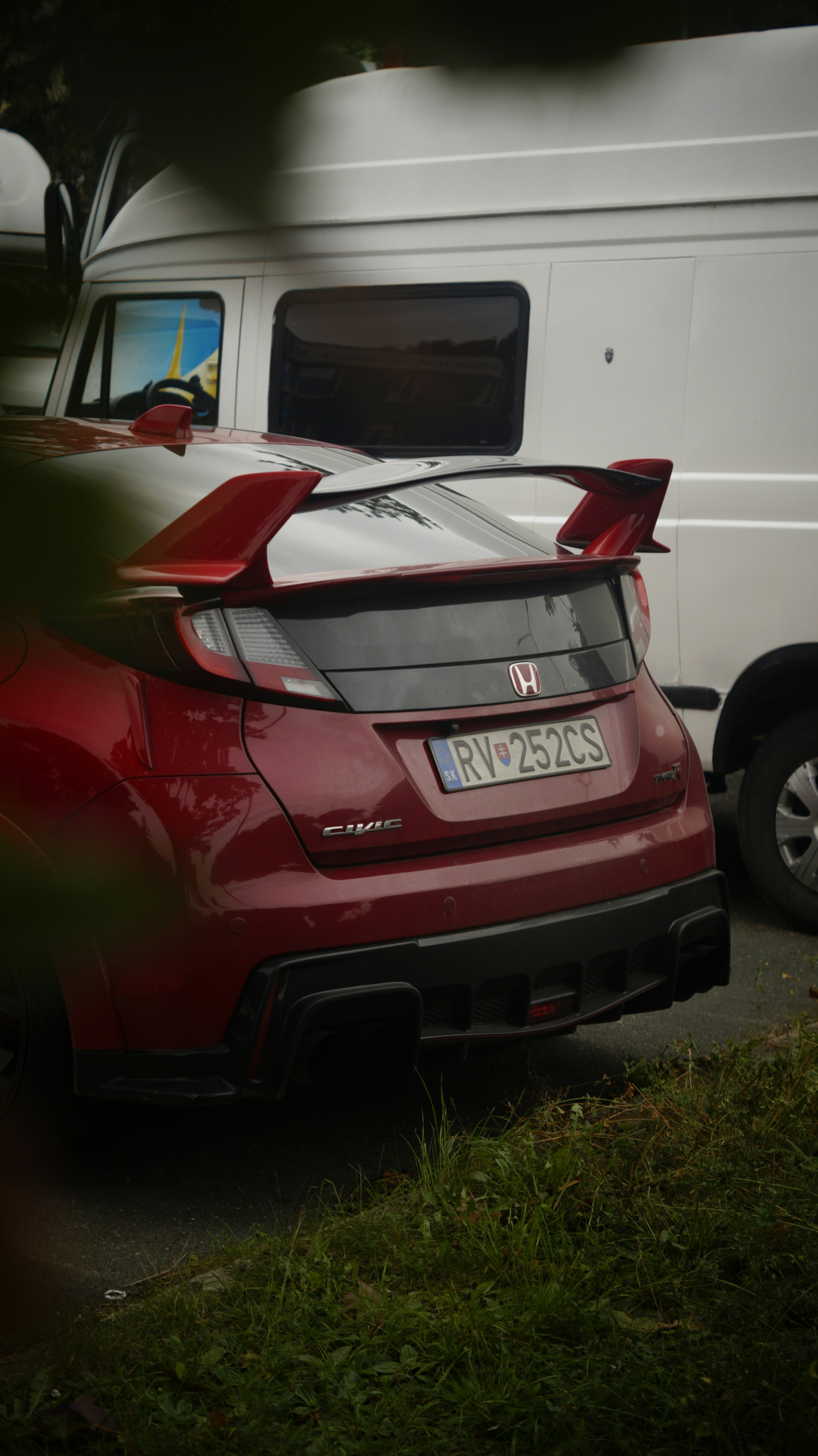 A red car parked next to a white van