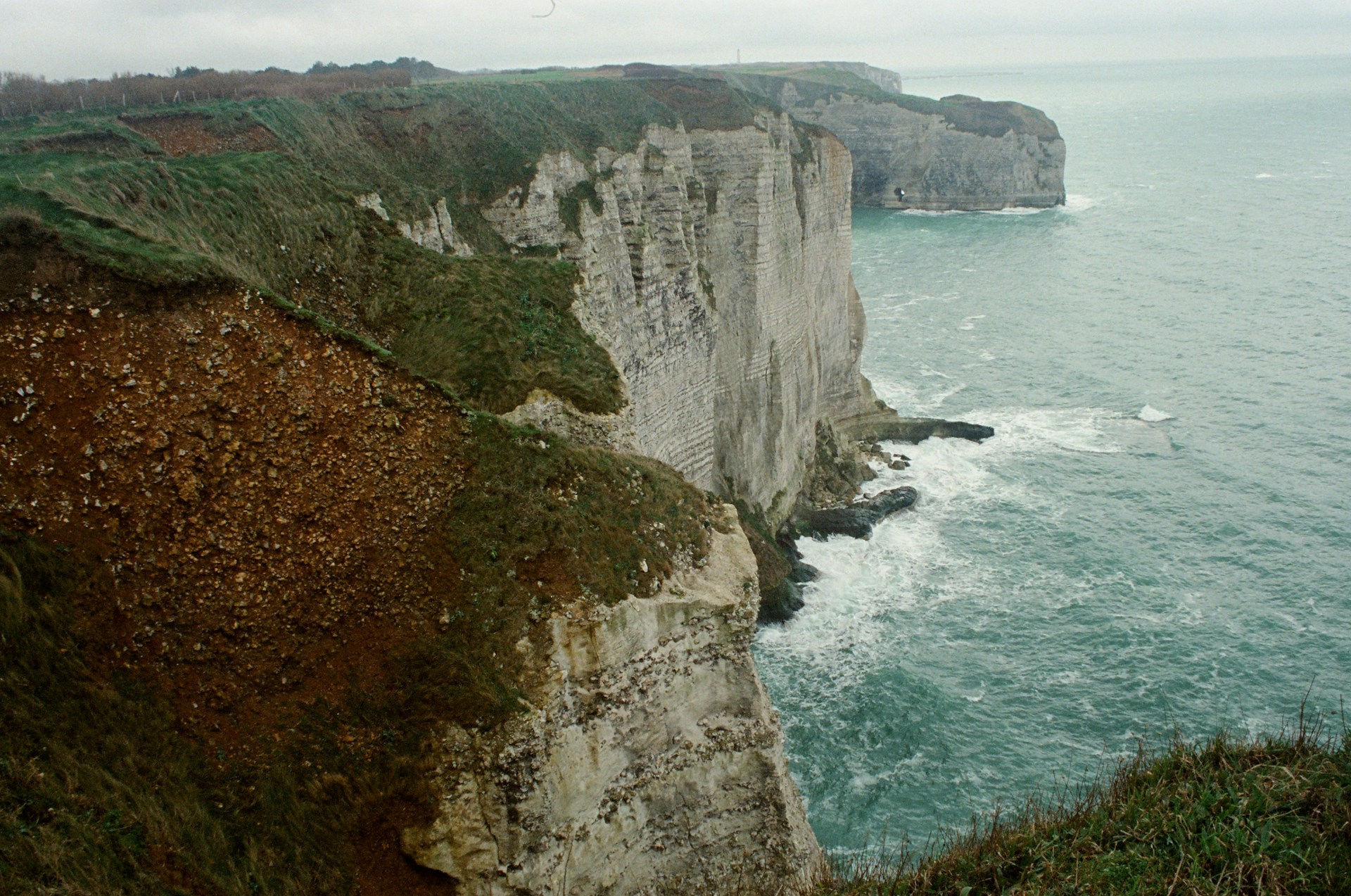 A cliff overlooking the ocean on a cloudy day