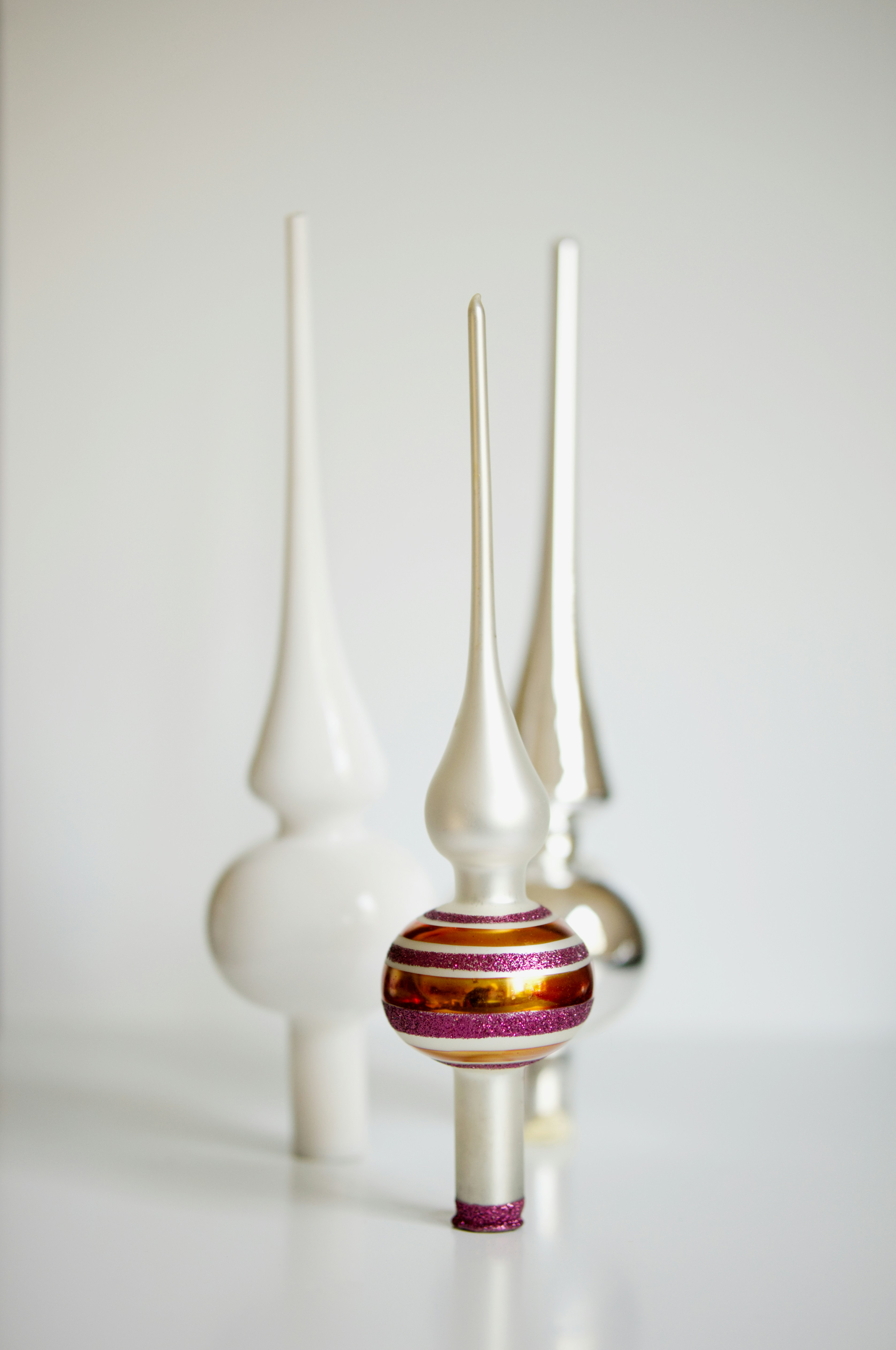 Three white vases sitting on top of a white table