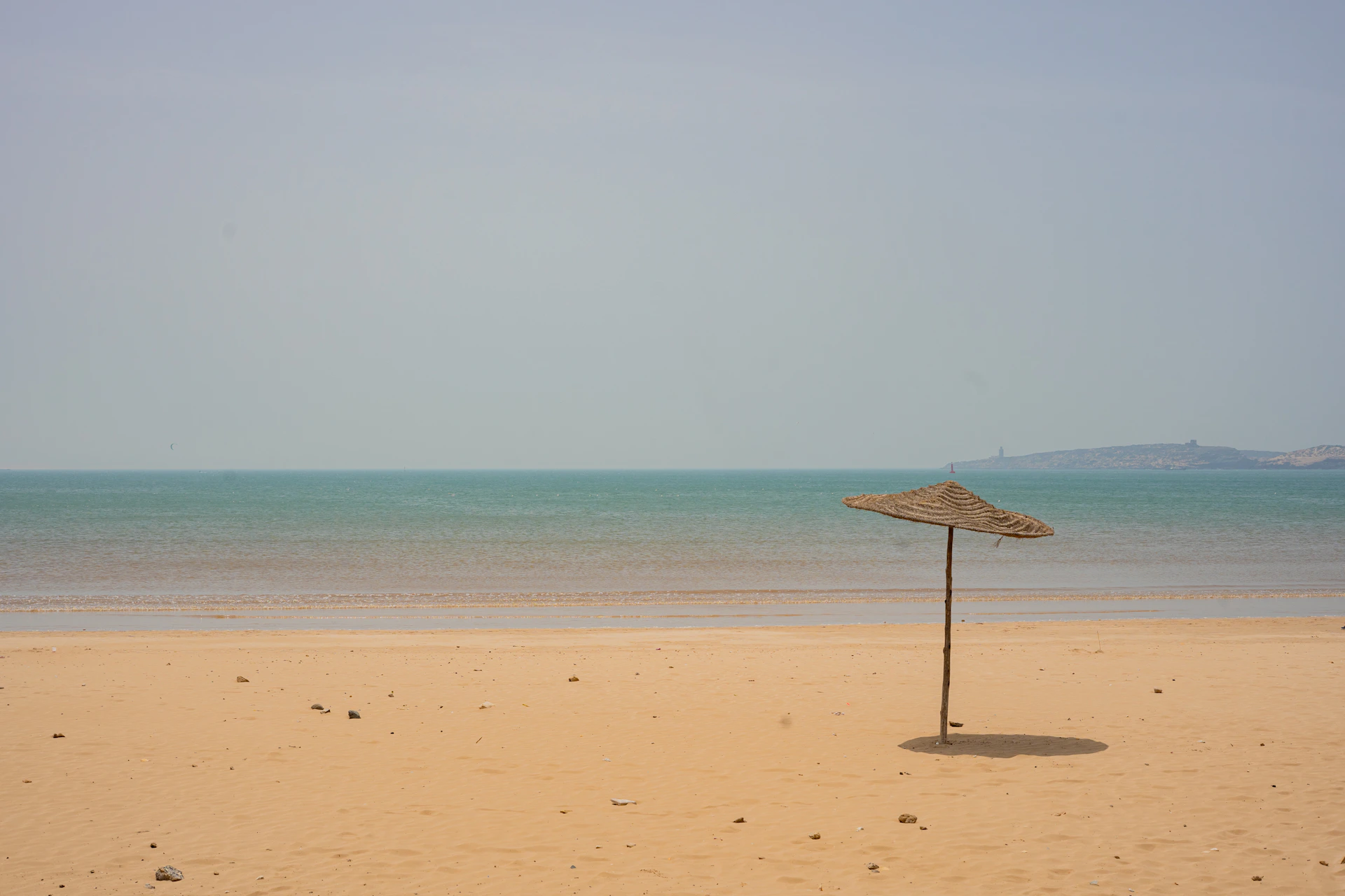 An umbrella on a sandy beach near the ocean