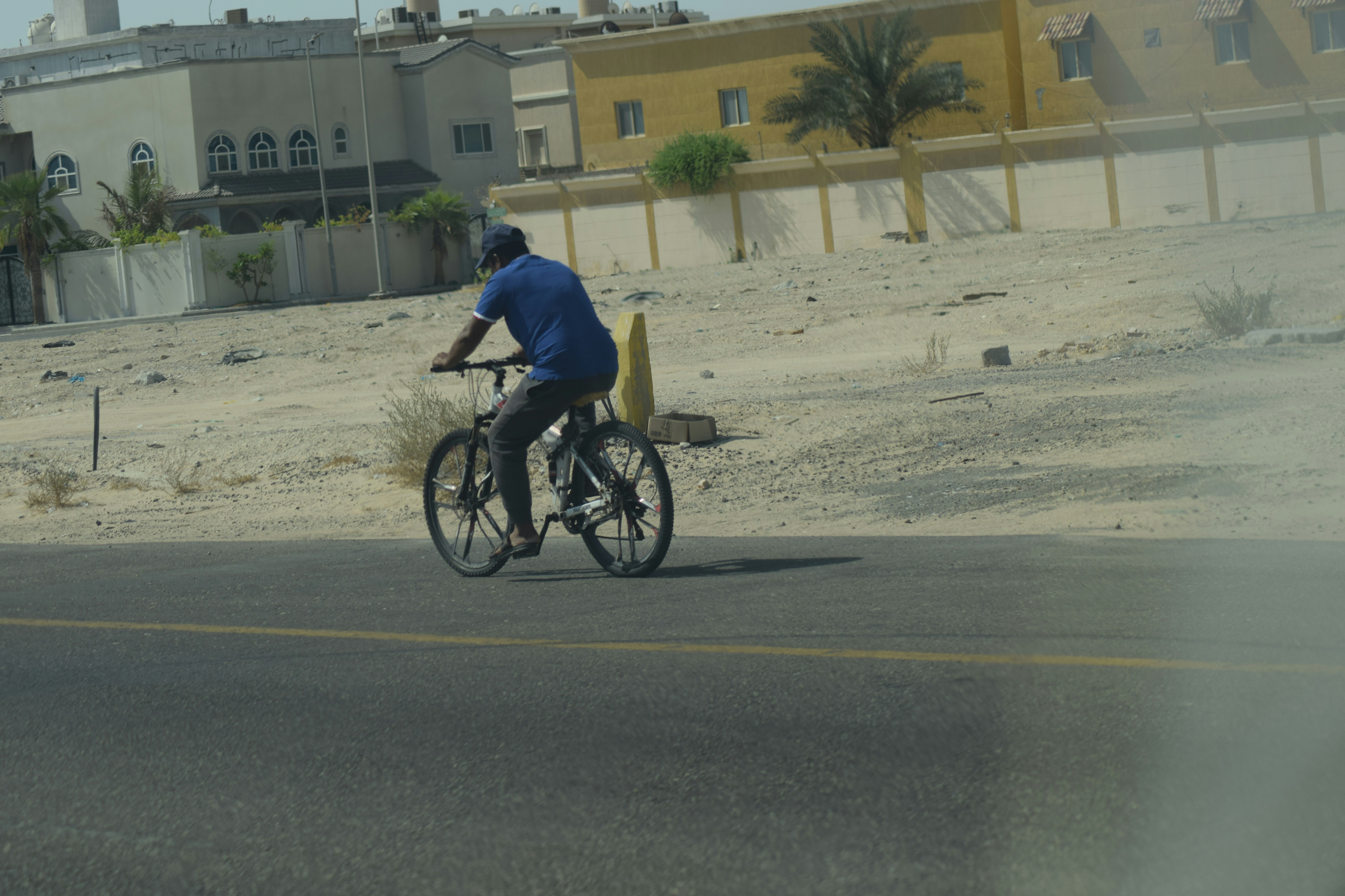 A man riding a bike down the middle of a street