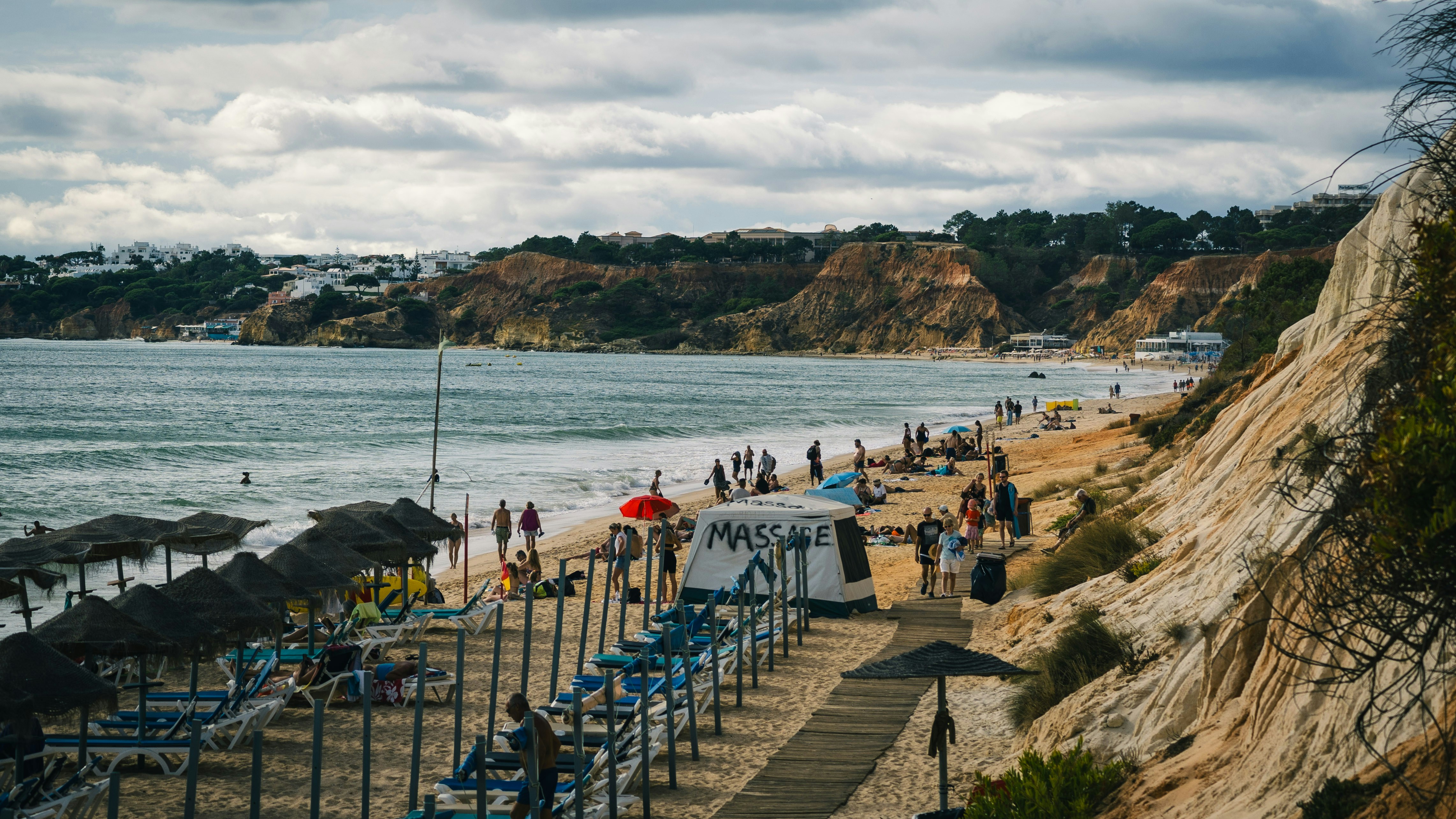 A group of people standing on top of a sandy beach