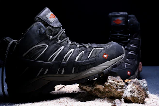 A pair of hiking shoes sitting on top of a rock