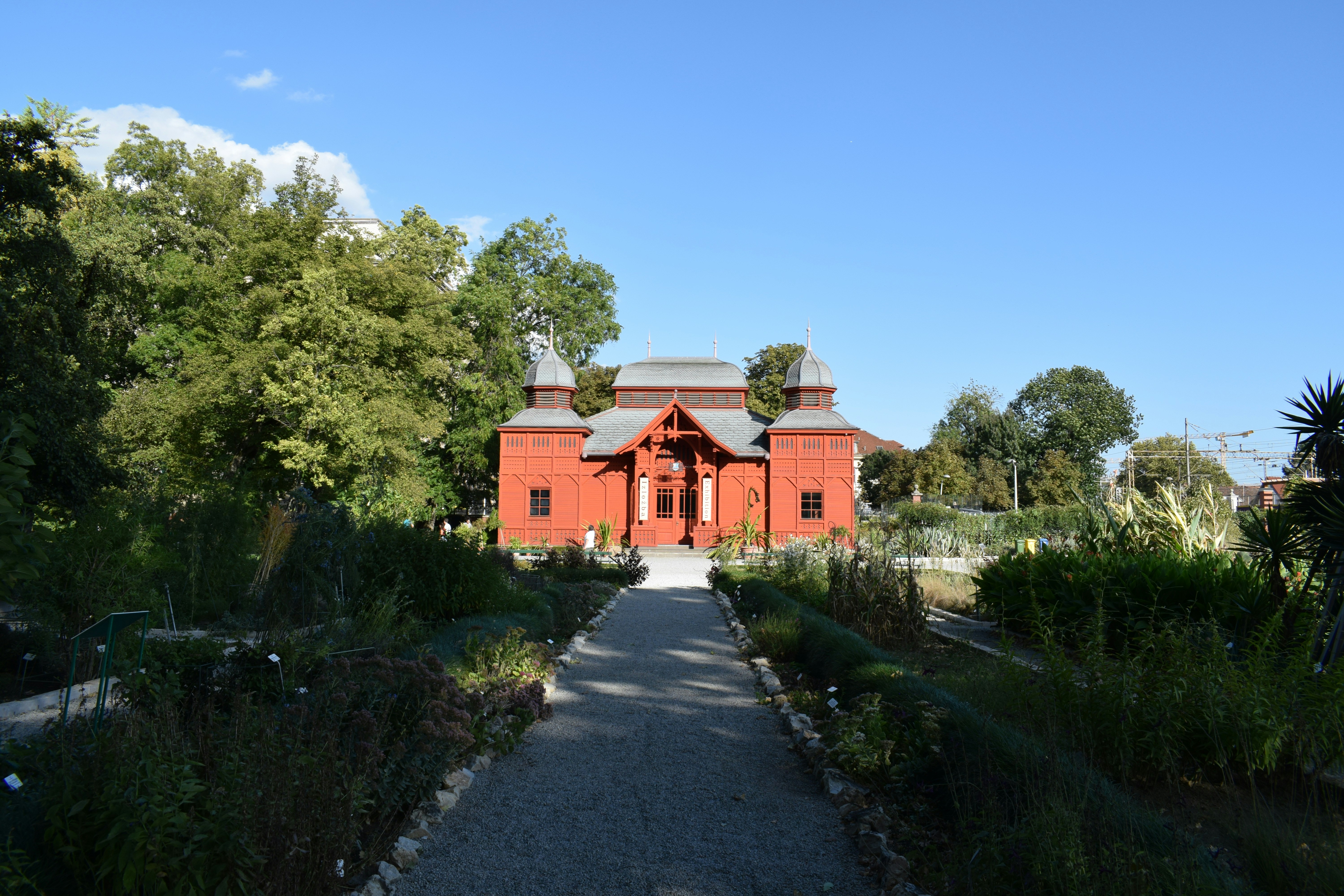 A large red building sitting next to a lush green forest