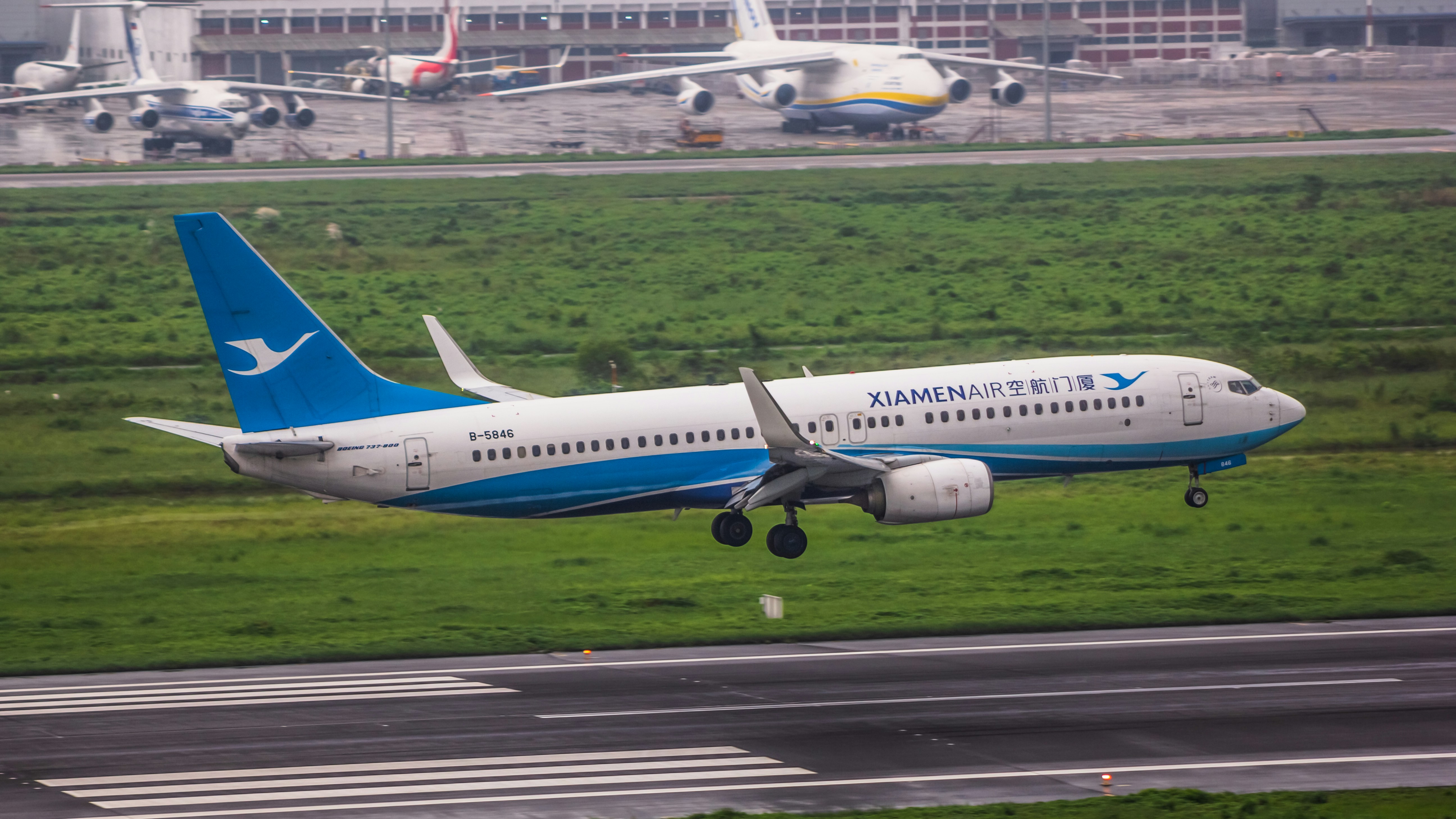 A blue and white airplane taking off from an airport runway photo ...