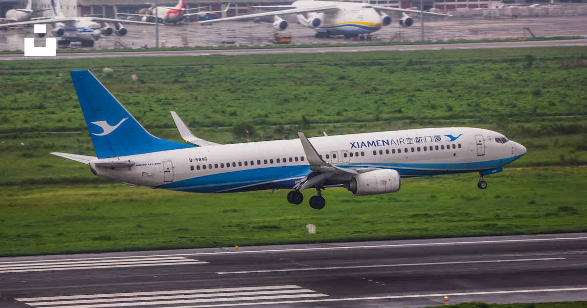 A blue and white airplane taking off from an airport runway photo ...