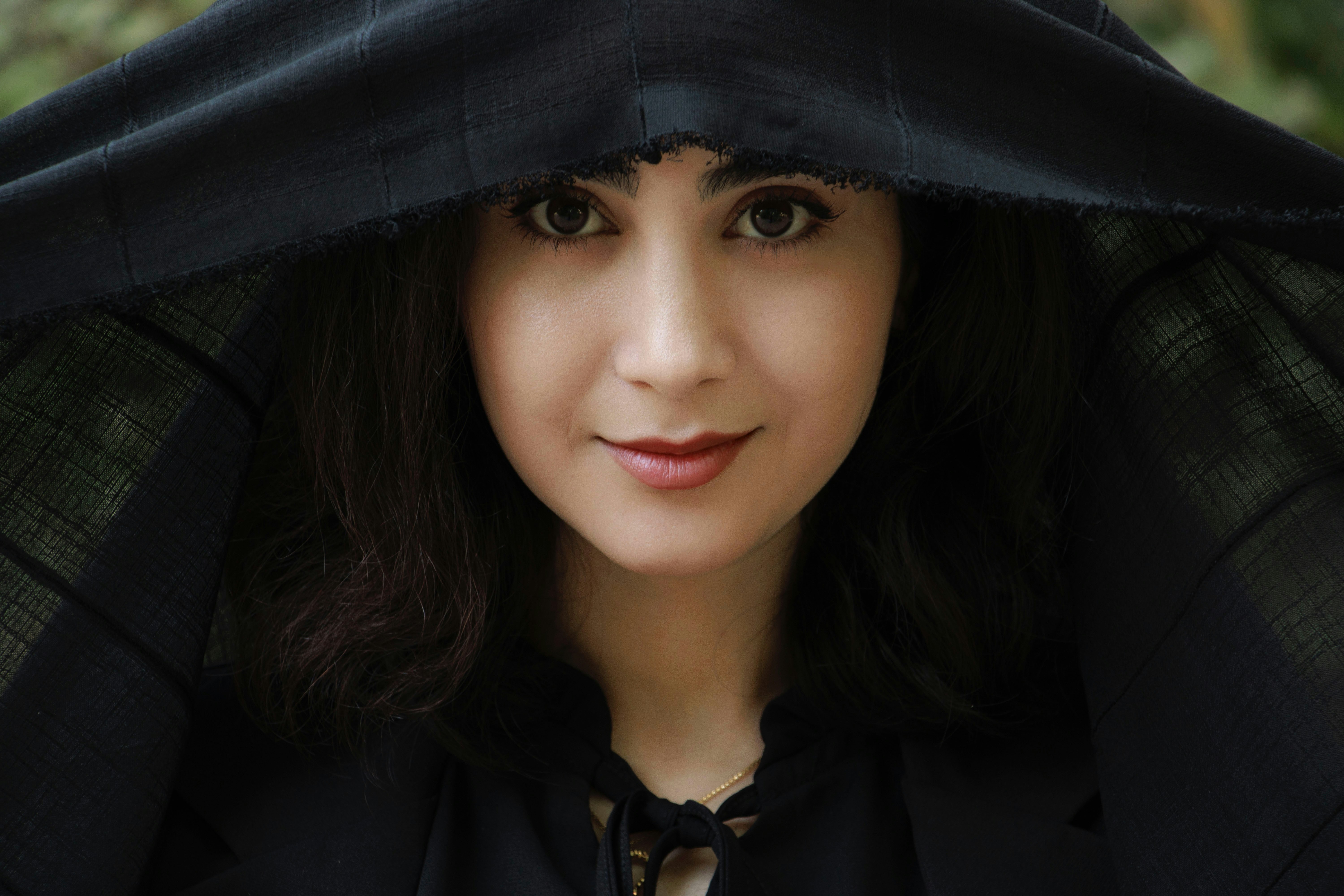 A woman wearing a black hoodie with a hood on her head photo – Free ...