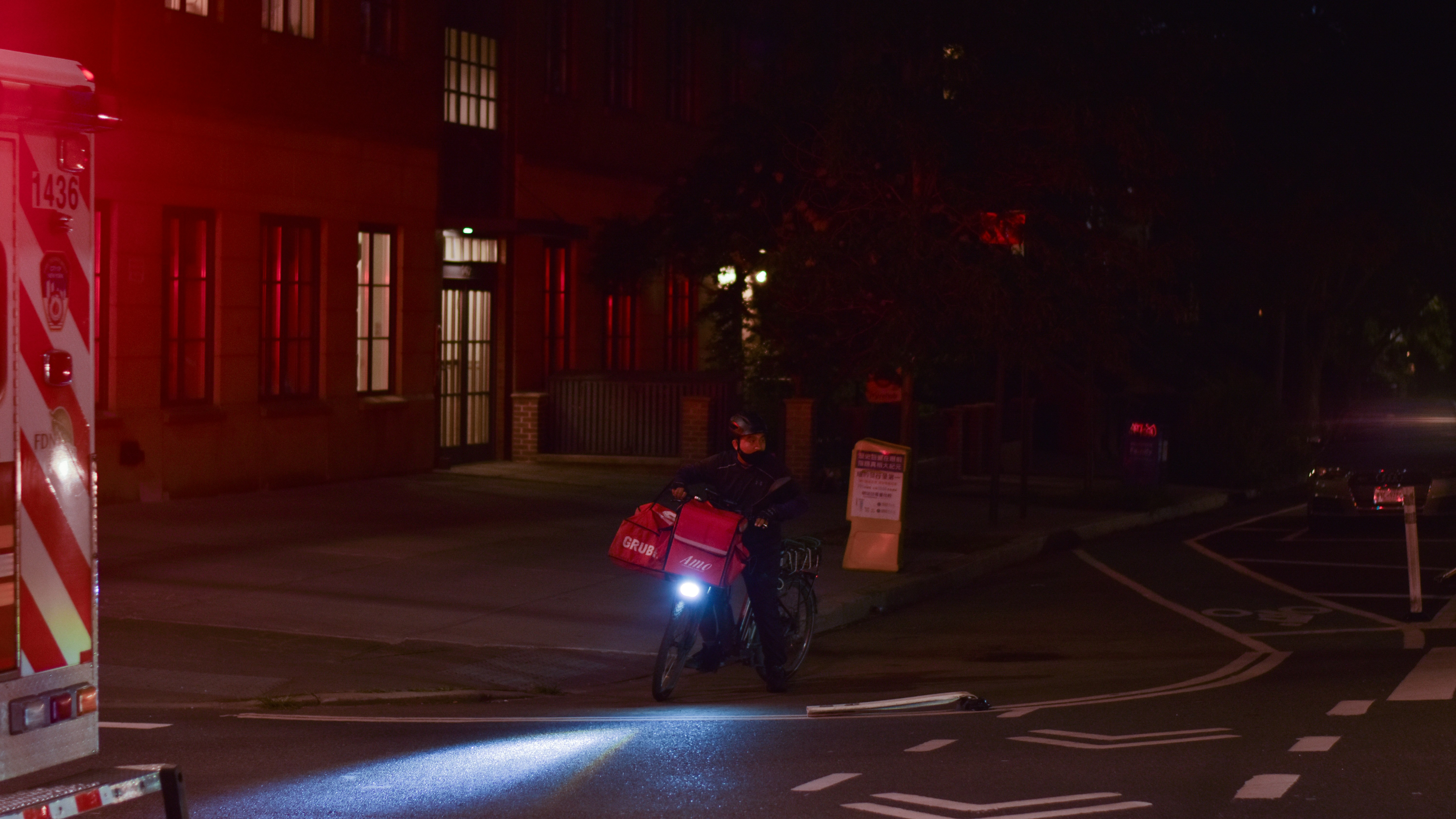 A person riding a motorcycle on a city street at night