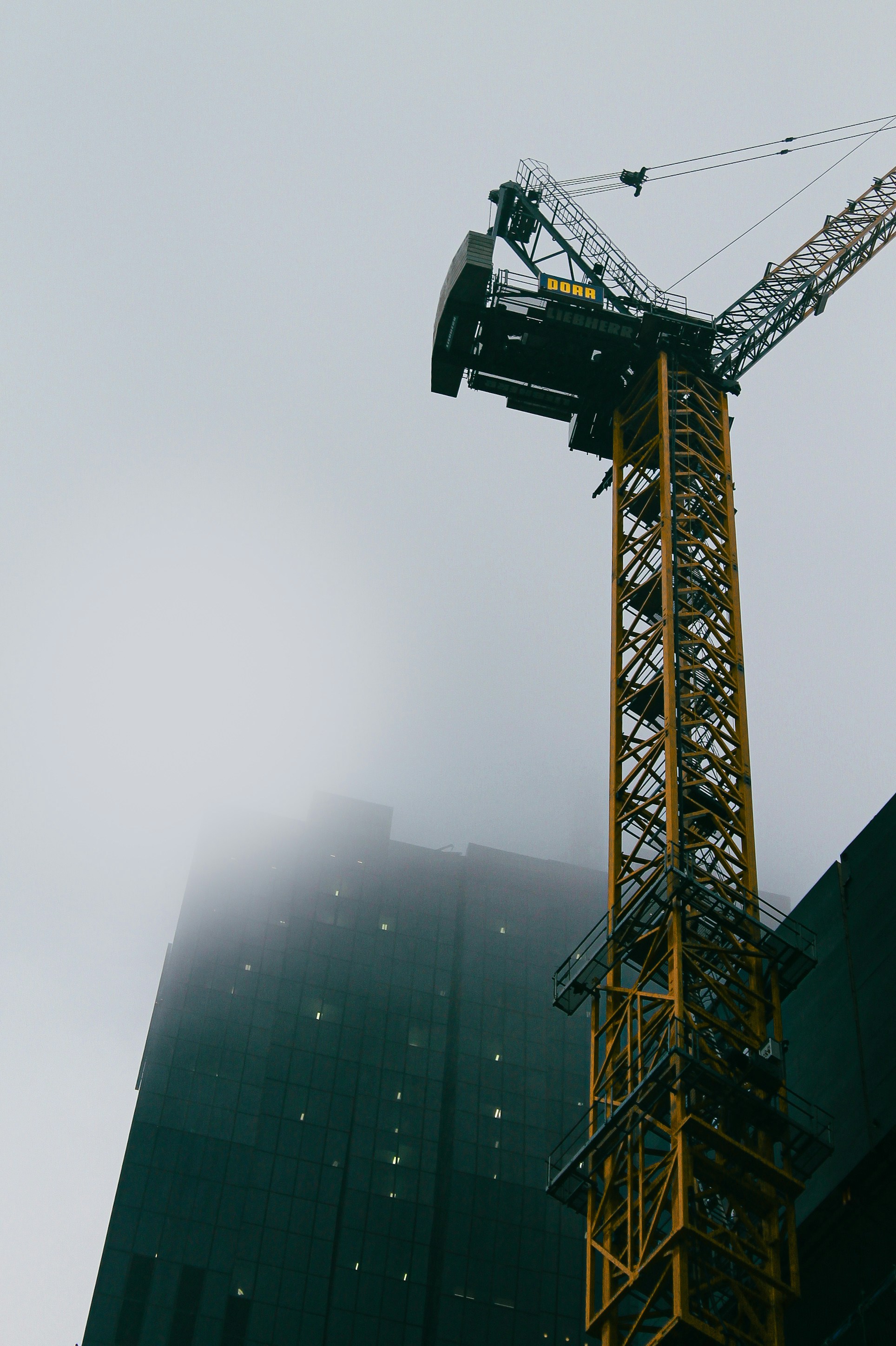 Ein Kran steht vor einem hohen Gebäude