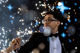 A man and a woman standing next to each other in front of fireworks