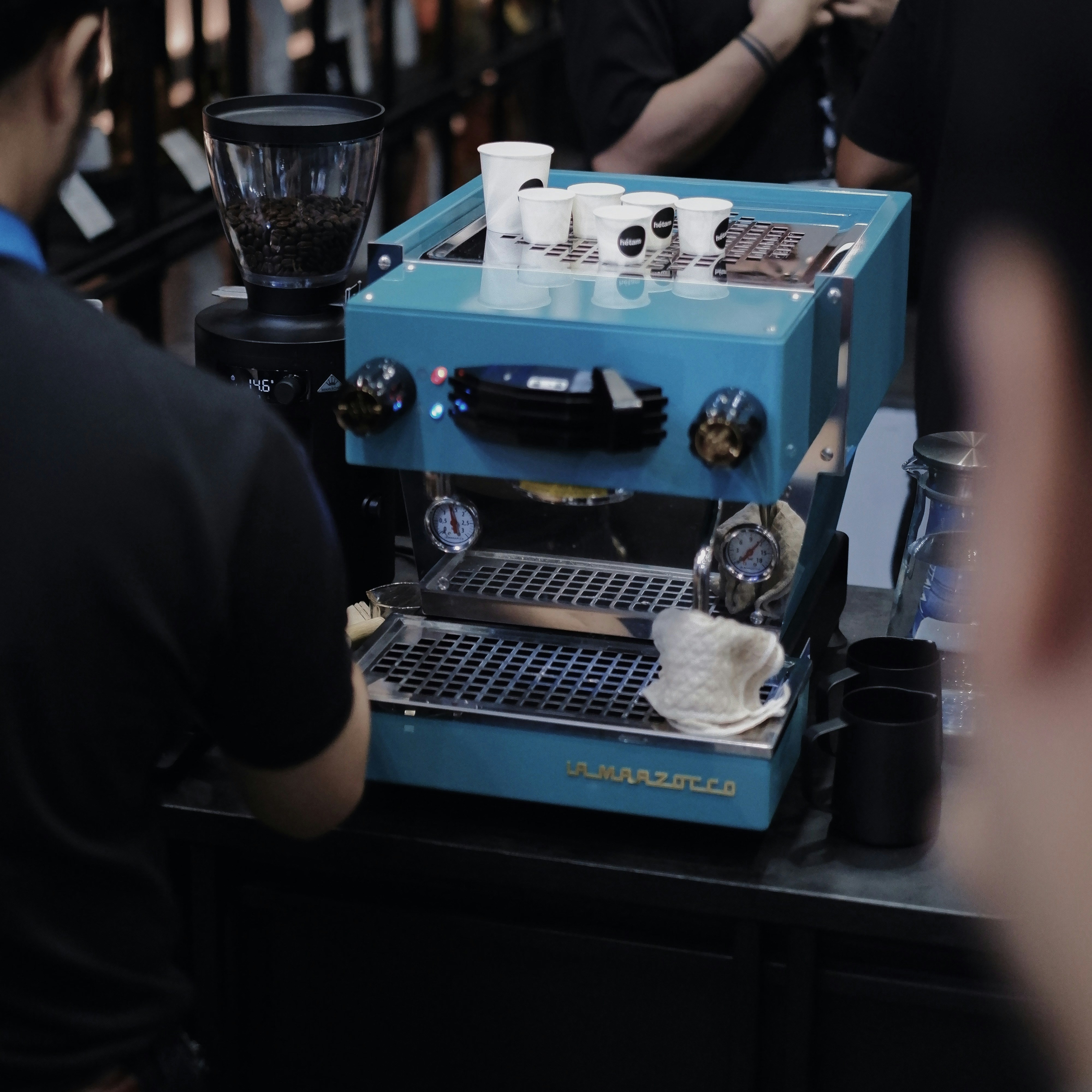 Un groupe de personnes debout autour d’une machine à café