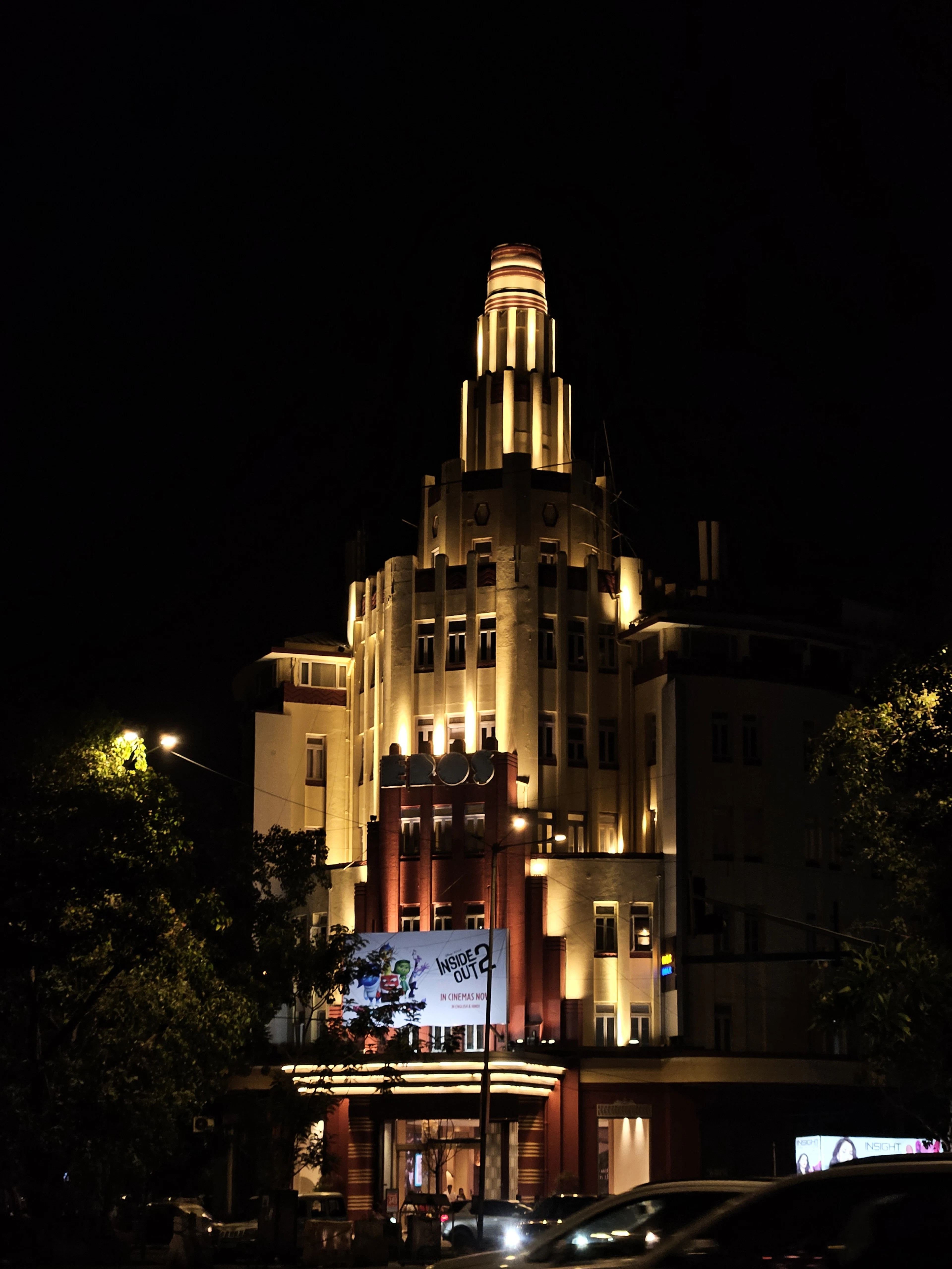 A grand cinema building lit up at night