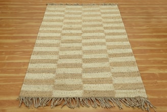 A brown and white rug on a wooden floor