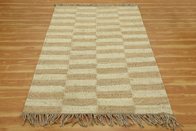 A brown and white rug on a wooden floor