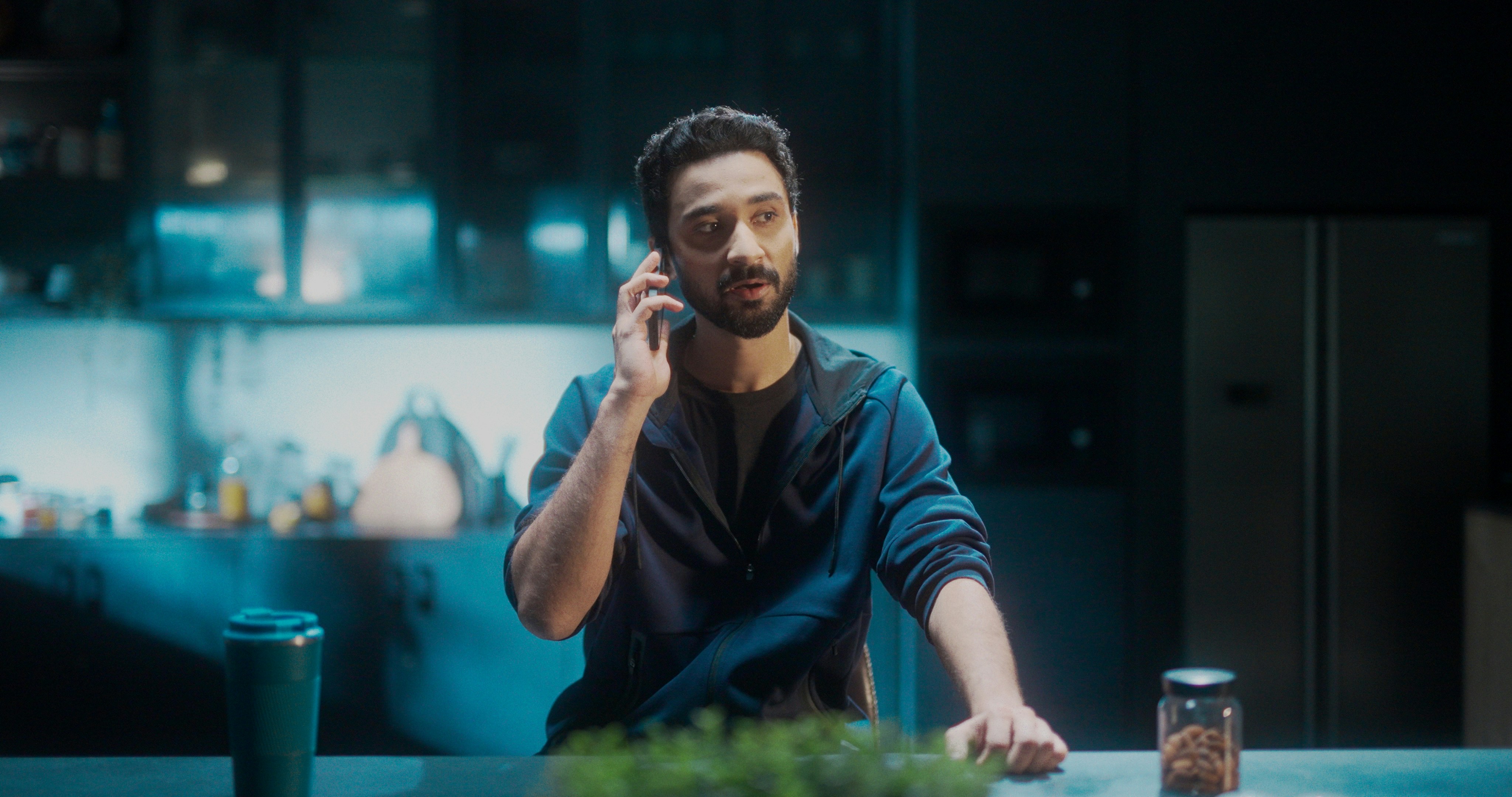 person talking to phone assistant in modern kitchen