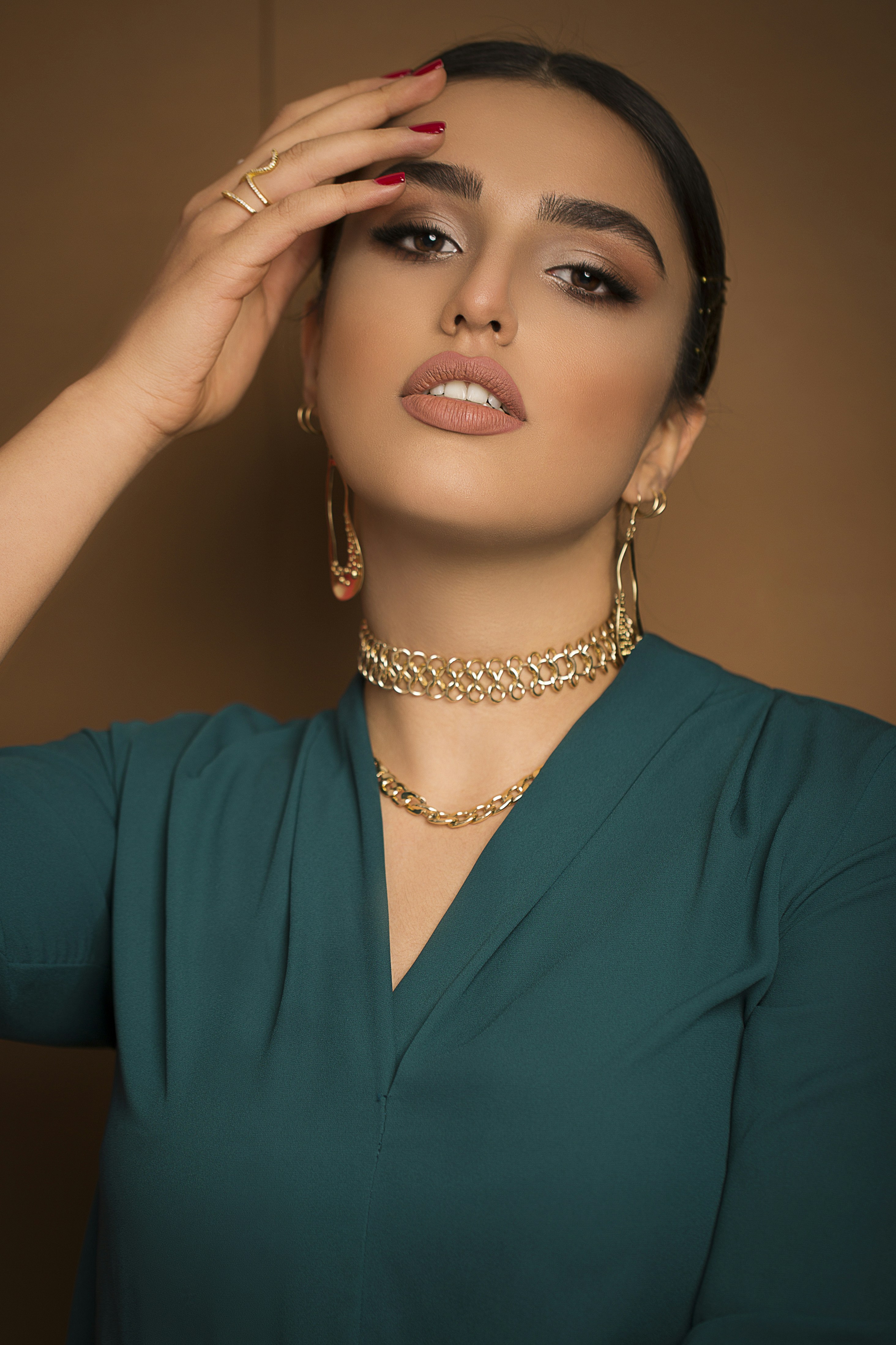 A woman in a green dress holding her hands to her face