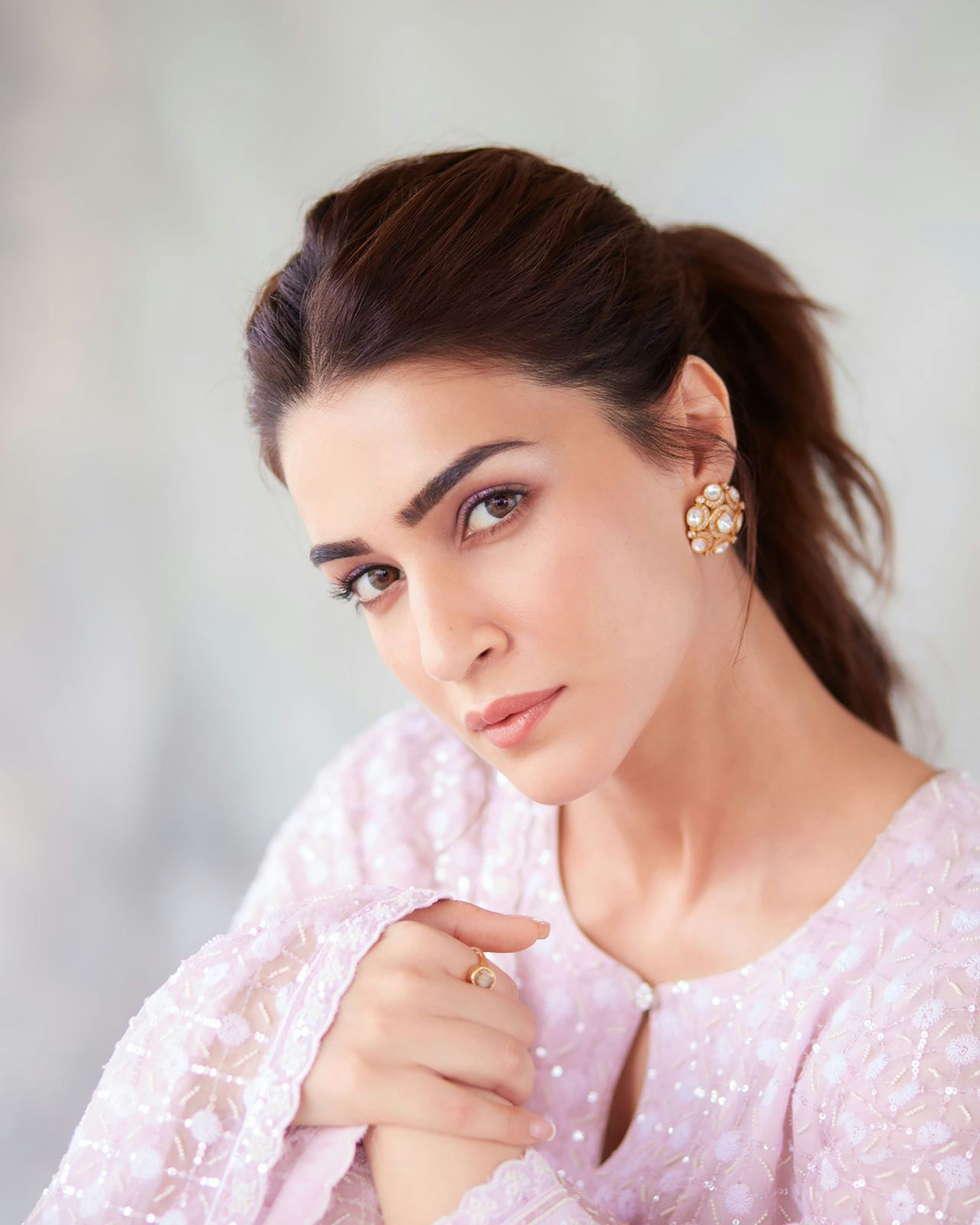 A woman in a pink dress is posing for a picture