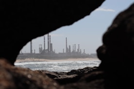 A view of an oil refinery through a hole in a rock
