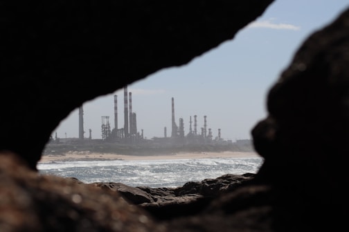 A view of an oil refinery through a hole in a rock