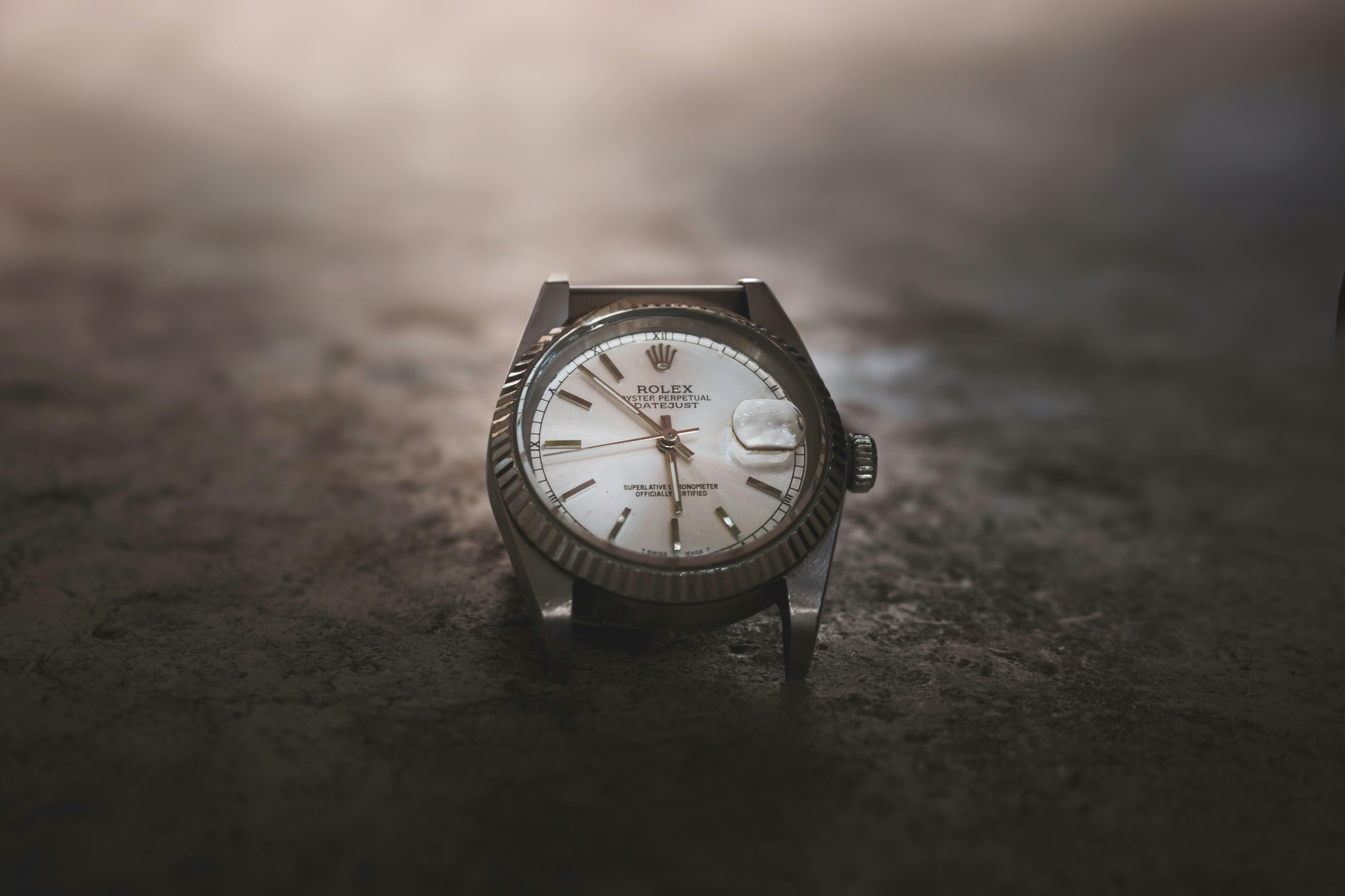 A watch sitting on the ground in the rain