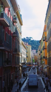 A van is driving down a narrow street