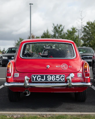 A red car is parked in a parking lot