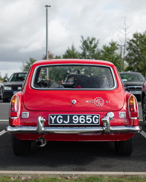 A red car is parked in a parking lot