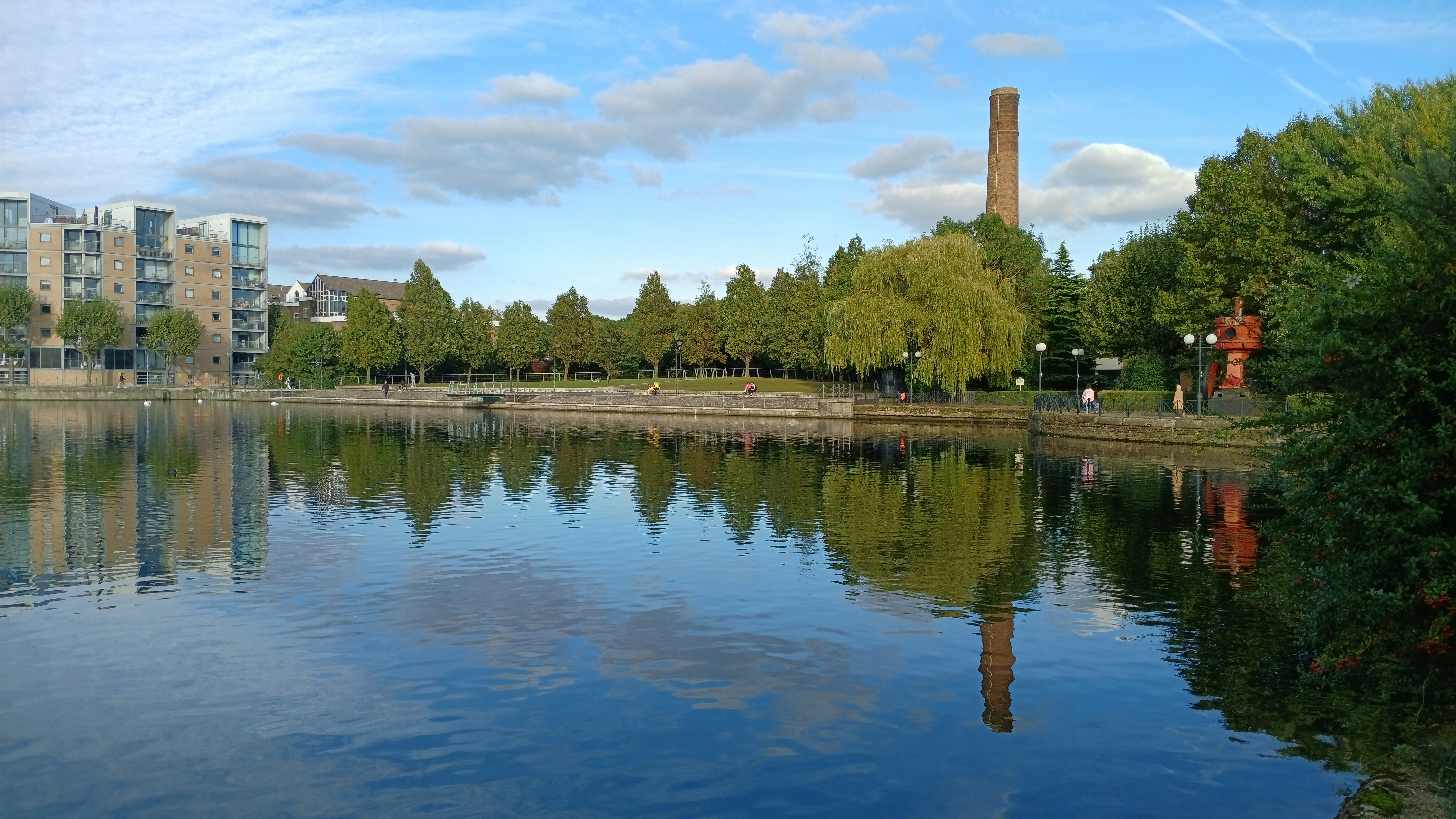A body of water surrounded by trees and buildings
